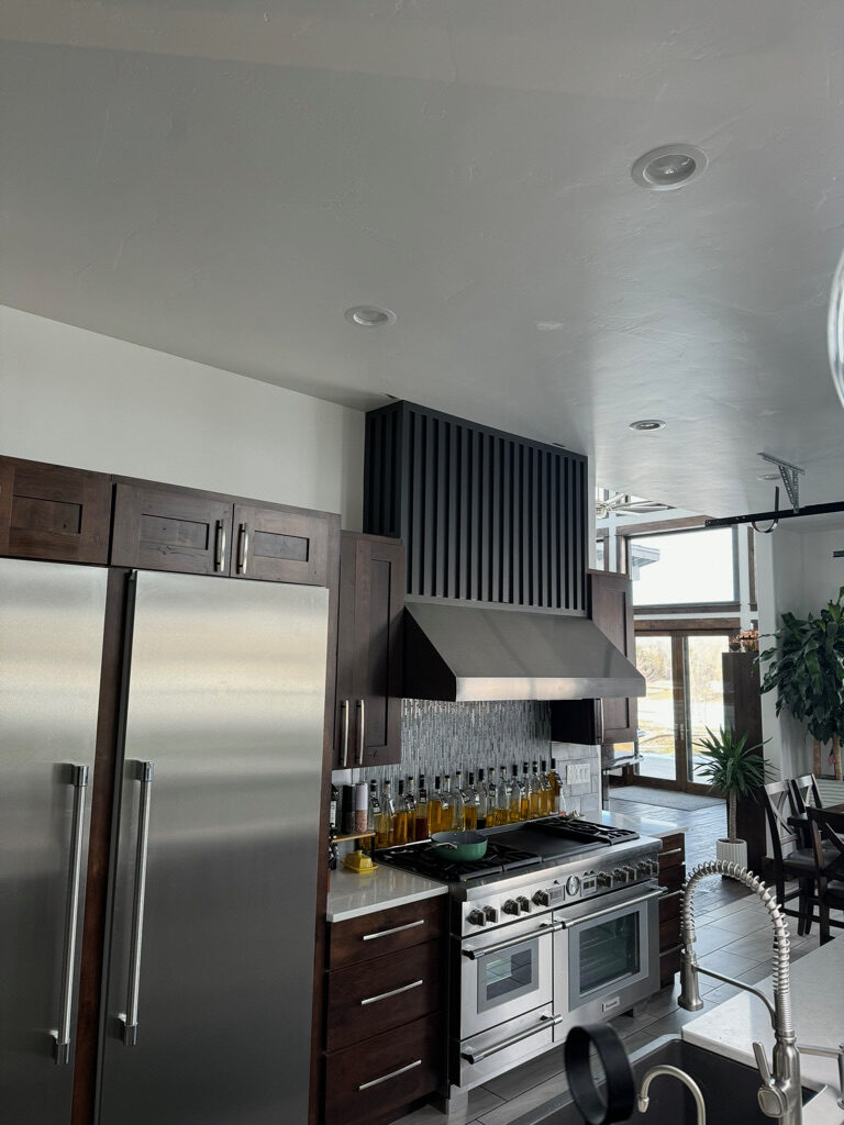 Finished kitchen with custom cabinetry and range hood
